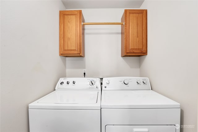 laundry room featuring washing machine and dryer and cabinets