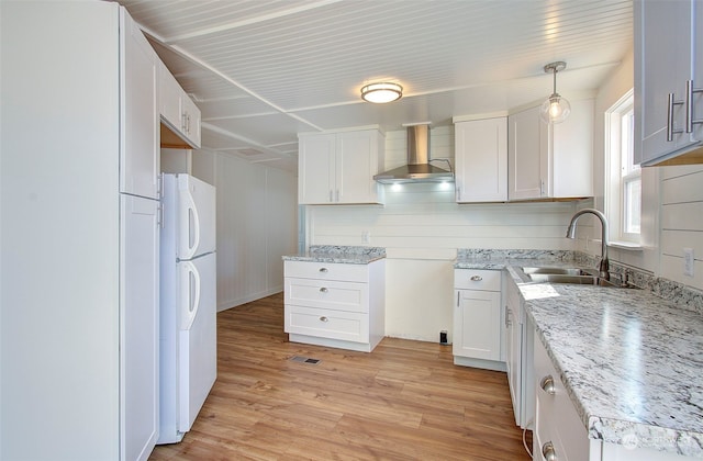 kitchen with wall chimney exhaust hood, sink, light wood-type flooring, white refrigerator, and white cabinets