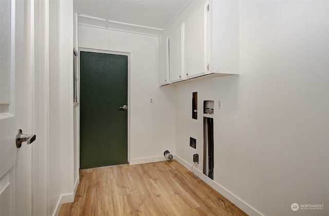 laundry room with washer hookup, light hardwood / wood-style floors, and cabinets