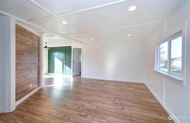 unfurnished room with hardwood / wood-style flooring and wood walls