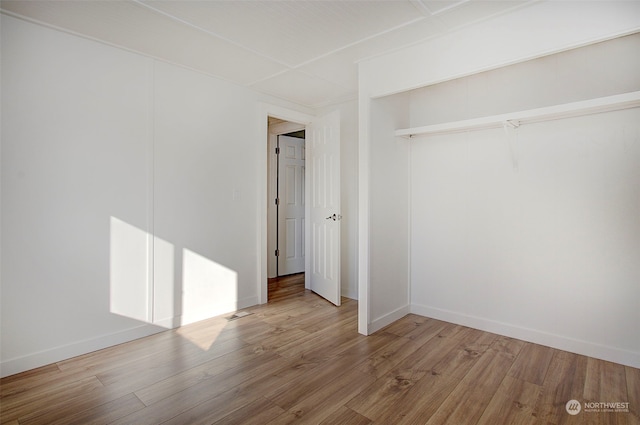 unfurnished bedroom with a closet and hardwood / wood-style floors