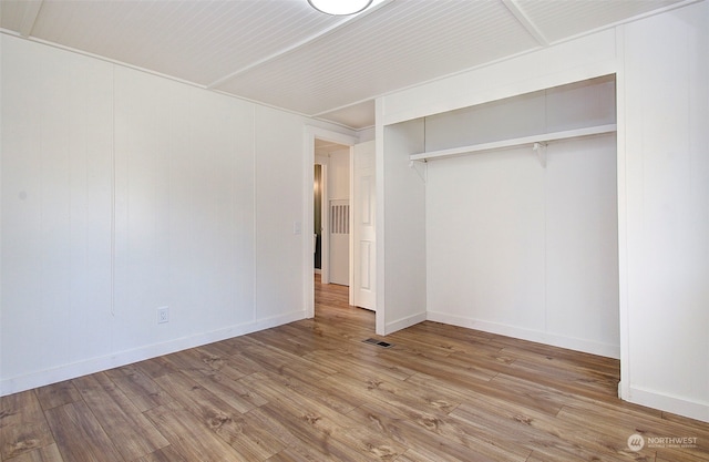 unfurnished bedroom with a closet and light hardwood / wood-style floors