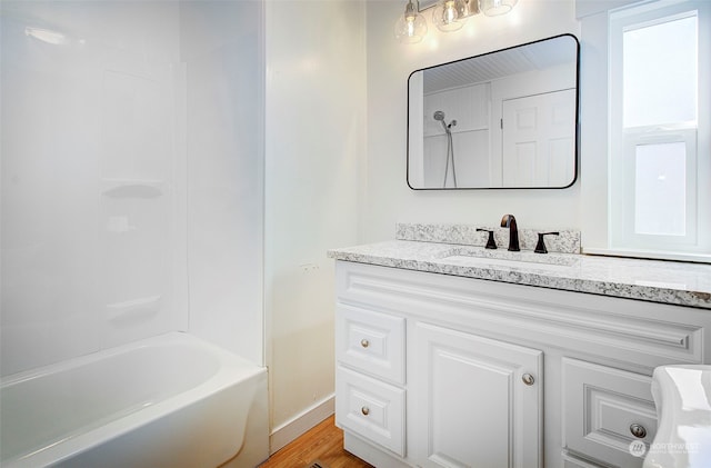 bathroom featuring vanity, hardwood / wood-style flooring, and  shower combination