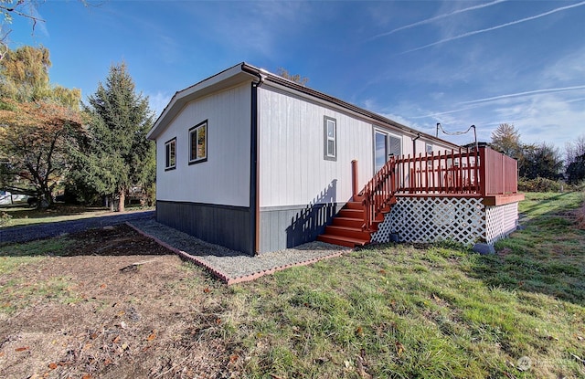 view of home's exterior with a wooden deck and a yard