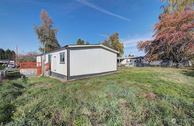 view of property exterior featuring a wooden deck and a yard