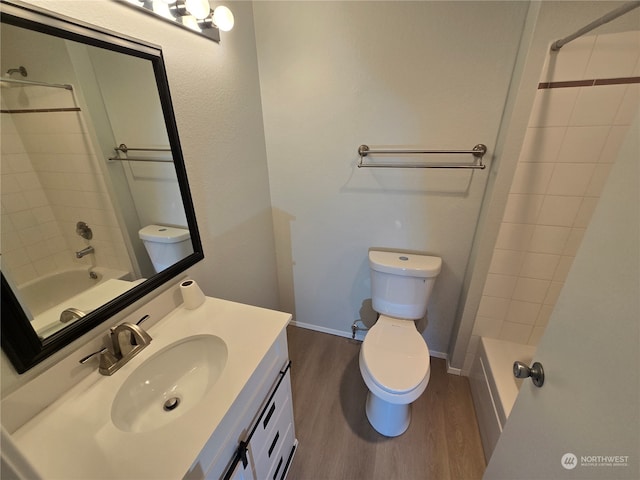 full bathroom featuring vanity, tiled shower / bath combo, wood-type flooring, and toilet