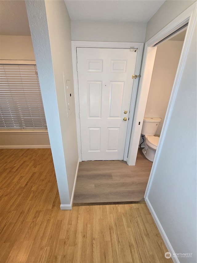 hallway with light hardwood / wood-style floors