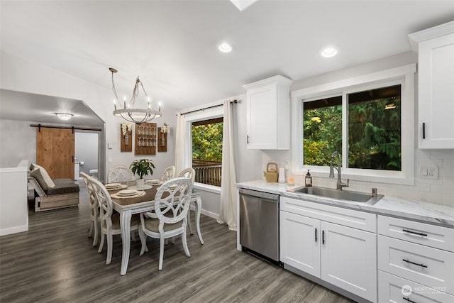 kitchen featuring sink, dishwasher, a barn door, white cabinetry, and dark hardwood / wood-style floors