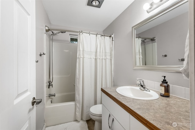 full bathroom featuring vanity, shower / bath combo with shower curtain, and toilet