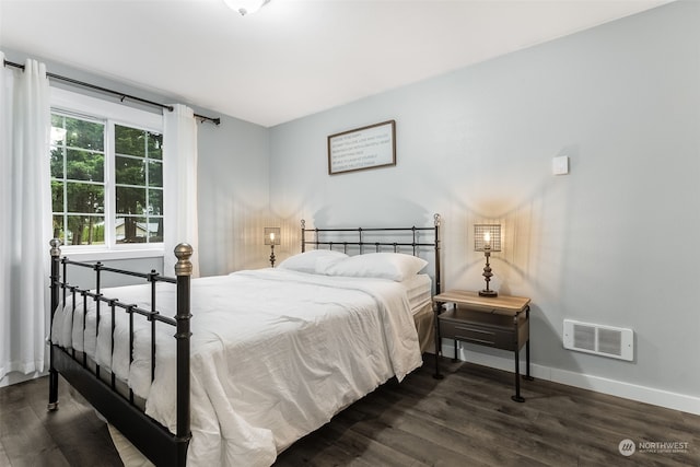 bedroom with dark hardwood / wood-style flooring