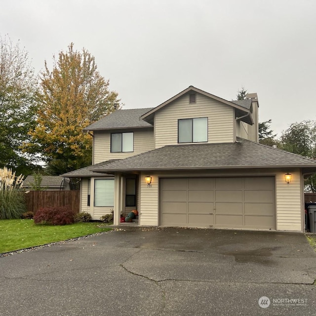 view of property featuring a garage and a front yard