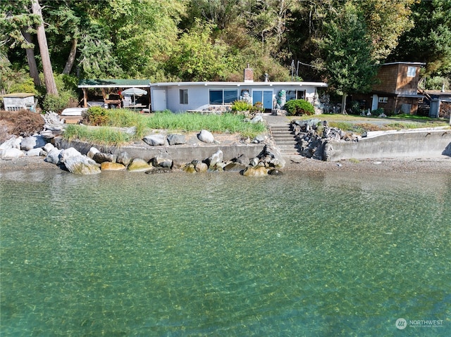 back of property featuring a water view