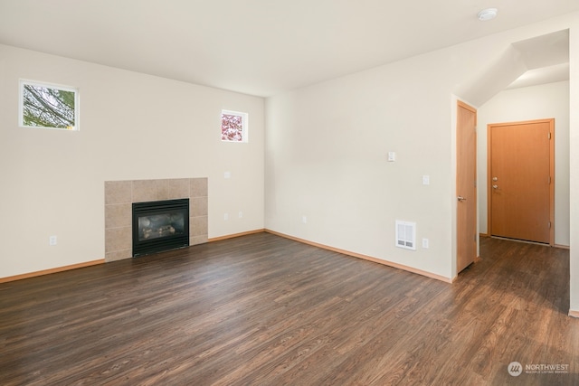 unfurnished living room with a tile fireplace and dark hardwood / wood-style flooring