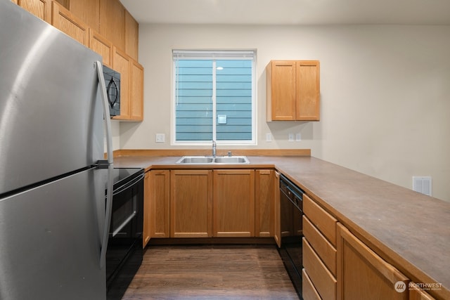 kitchen featuring sink, black appliances, dark wood-type flooring, and kitchen peninsula