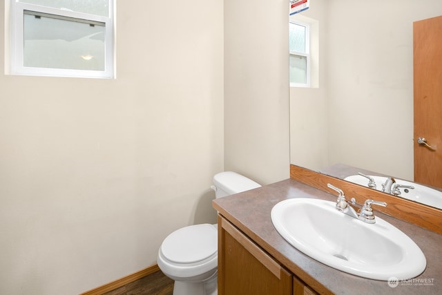 bathroom featuring vanity, toilet, and hardwood / wood-style floors