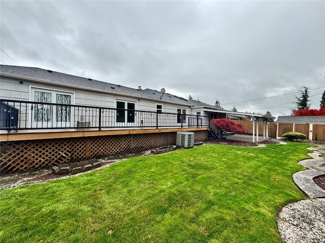 rear view of property with central air condition unit, a deck, and a lawn