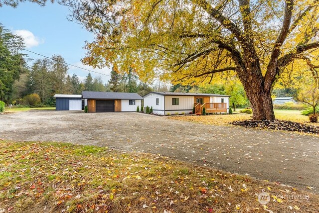 4249 88th Ave SW, Olympia, WA 98512 - view of front of home with a wooden deck, an outdoor structure, and a garage