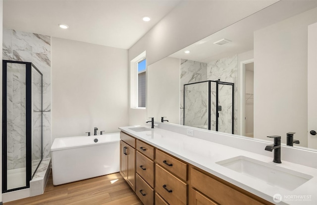 23557 Arbors Terrace Rd NE Unit 32, Kingston, WA 98346 - bathroom featuring a marble finish shower, double vanity, a freestanding bath, wood finished floors, and recessed lighting