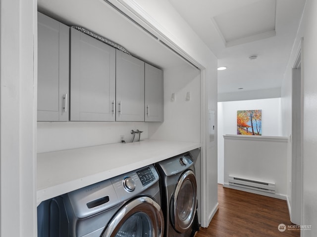 washroom with dark wood-type flooring, cabinets, a baseboard radiator, and washing machine and clothes dryer