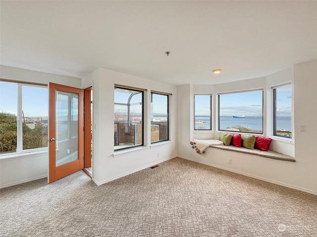 unfurnished sunroom with a wealth of natural light and a water view