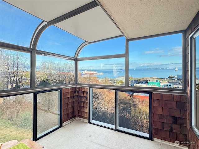 unfurnished sunroom with a water view