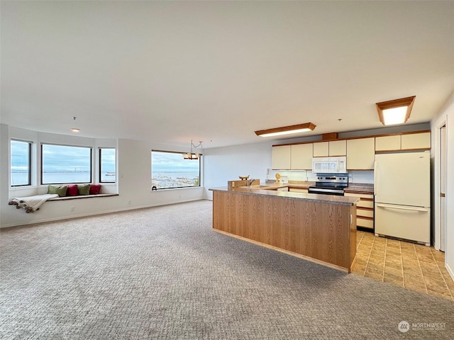 226 W 2nd St Unit 4, Port Angeles, WA 98362 - kitchen with white appliances, light colored carpet, open floor plan, and an island with sink