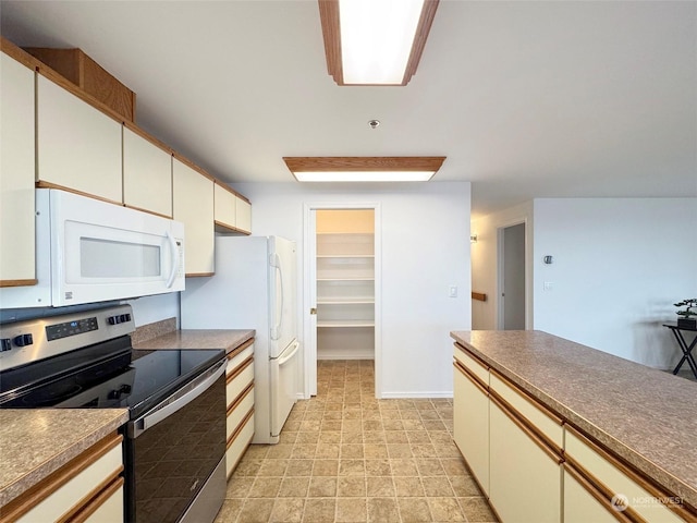 kitchen with stainless steel electric stove and white cabinetry