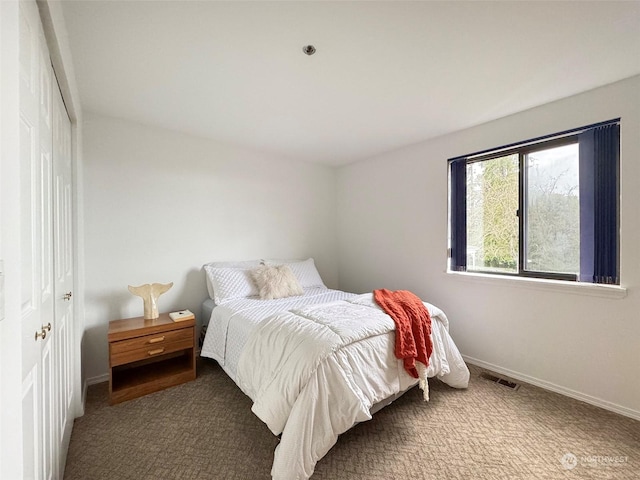 bedroom featuring dark carpet and a closet