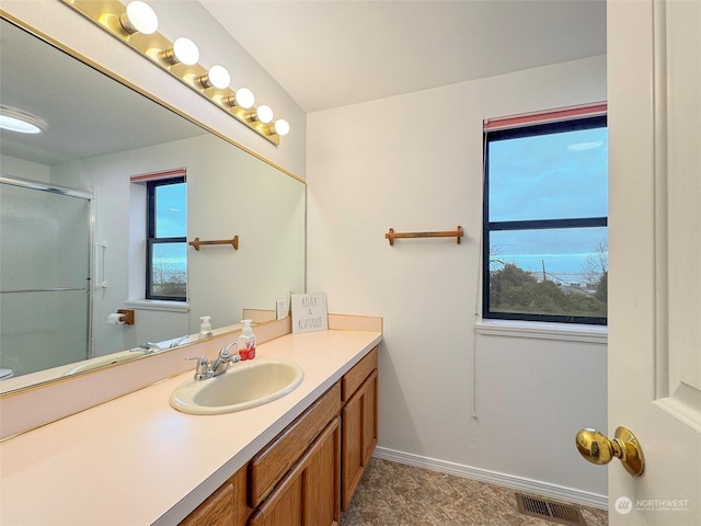 bathroom with plenty of natural light, vanity, and a shower with door