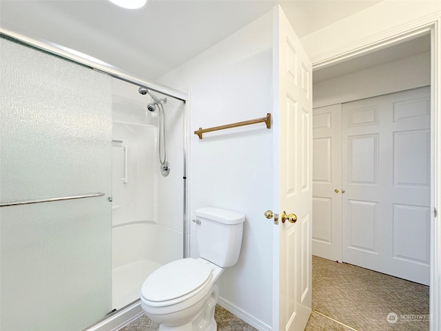 bathroom featuring tile patterned flooring, toilet, and an enclosed shower