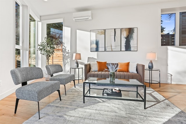 living room featuring a wall mounted air conditioner and light hardwood / wood-style flooring