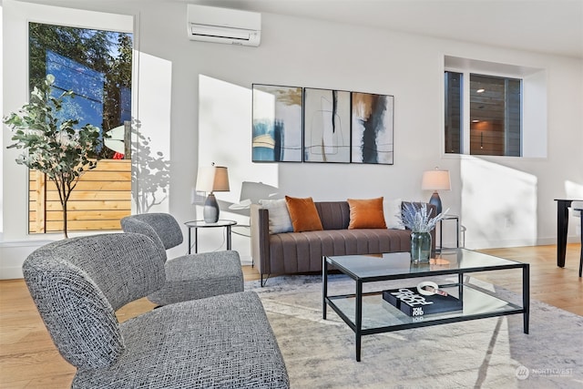 living room featuring an AC wall unit and light wood-type flooring