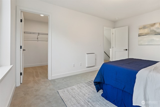 carpeted bedroom featuring a closet and a spacious closet