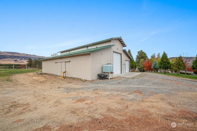 1114 S Wells, East Wenatchee, WA 98802 - view of side of home with a garage, a mountain view, and an outdoor structure