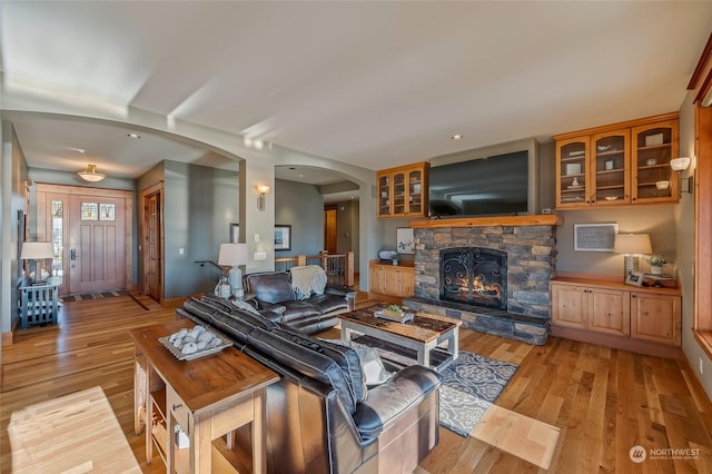 1114 S Wells, East Wenatchee, WA 98802 - living room with arched walkways, light wood-style flooring, and a fireplace