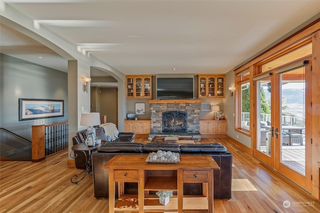 1114 S Wells, East Wenatchee, WA 98802 - living area with arched walkways, light wood-style flooring, and a stone fireplace
