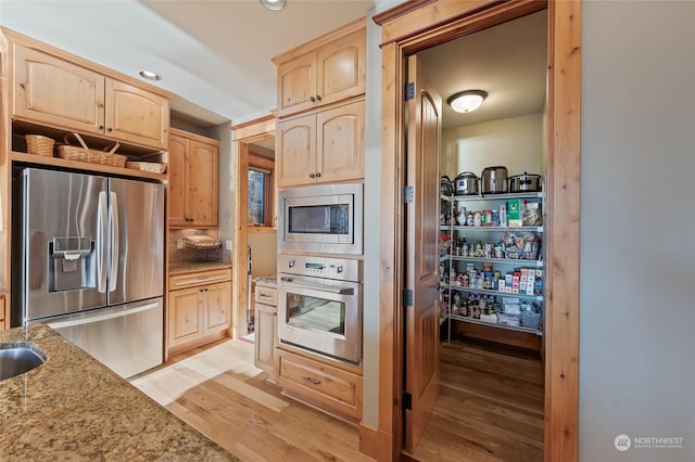 1114 S Wells, East Wenatchee, WA 98802 - kitchen with stainless steel appliances, light brown cabinetry, light wood finished floors, light stone countertops, and recessed lighting