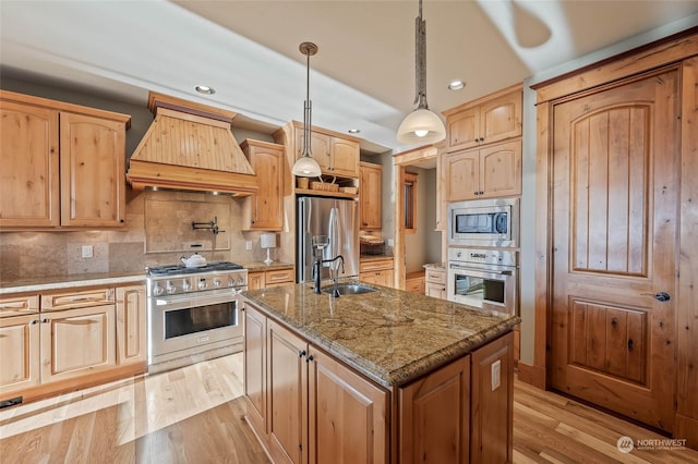 1114 S Wells, East Wenatchee, WA 98802 - kitchen featuring appliances with stainless steel finishes, premium range hood, a sink, light brown cabinetry, and light wood finished floors