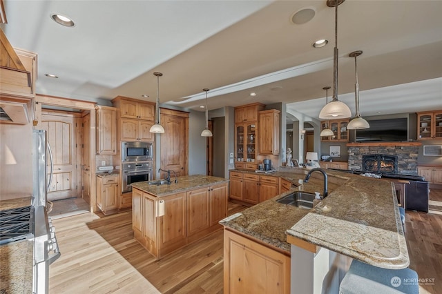 1114 S Wells, East Wenatchee, WA 98802 - kitchen featuring stainless steel appliances, a large island, a sink, recessed lighting, and glass insert cabinets