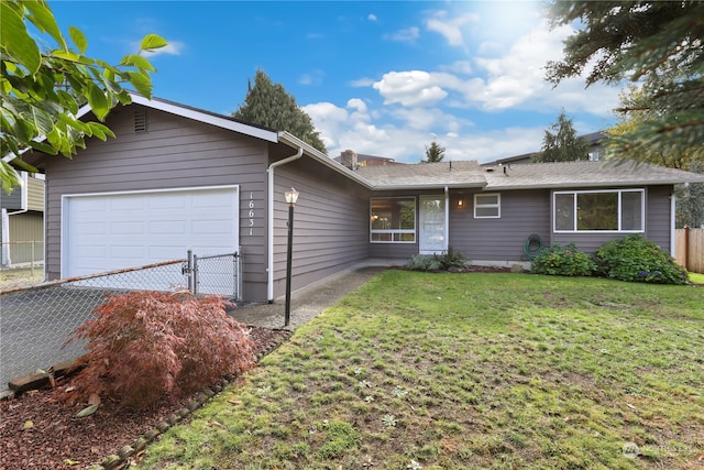 ranch-style house featuring a garage and a front lawn