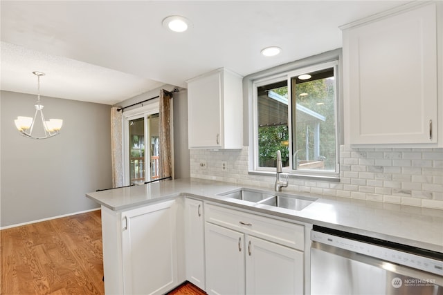 kitchen featuring sink, dishwasher, hanging light fixtures, white cabinets, and kitchen peninsula