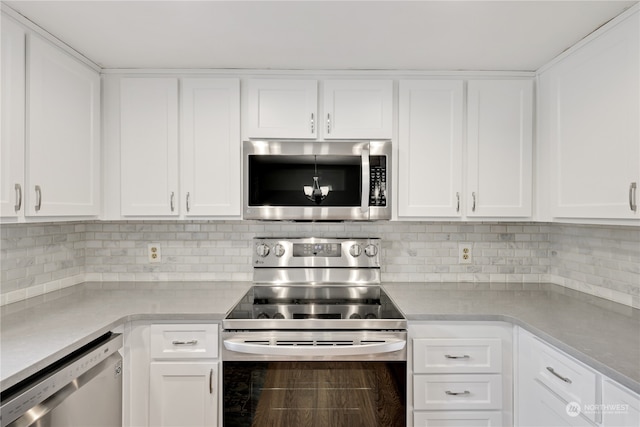 kitchen with appliances with stainless steel finishes, white cabinets, and backsplash