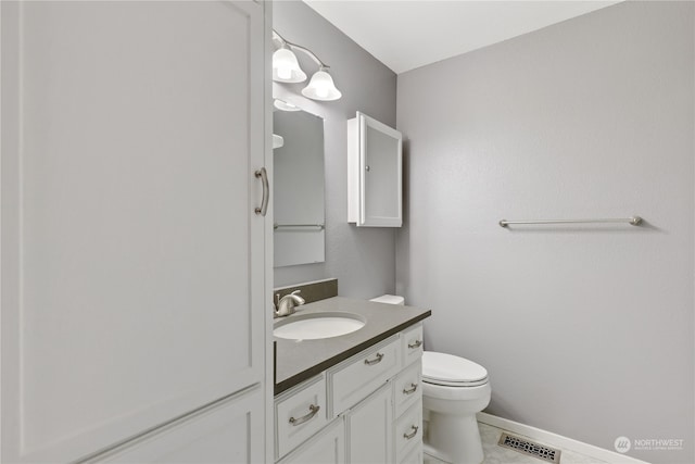 bathroom with tile patterned flooring, vanity, and toilet