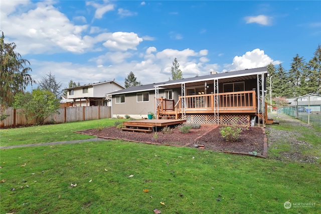 back of house featuring a wooden deck and a lawn