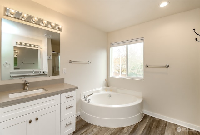 bathroom featuring vanity, hardwood / wood-style floors, and plus walk in shower