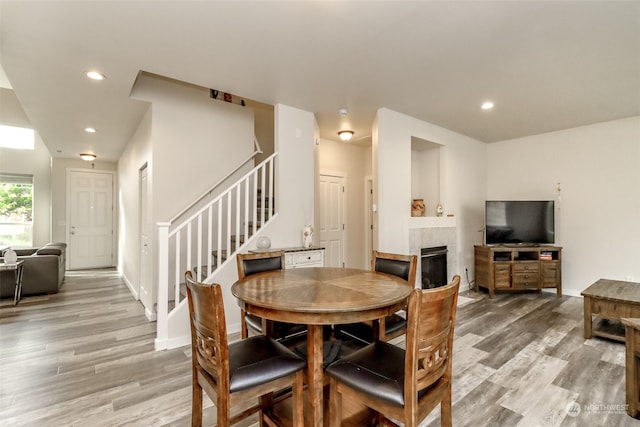 dining room featuring light hardwood / wood-style floors and a tile fireplace