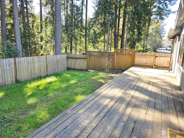 wooden terrace featuring a yard