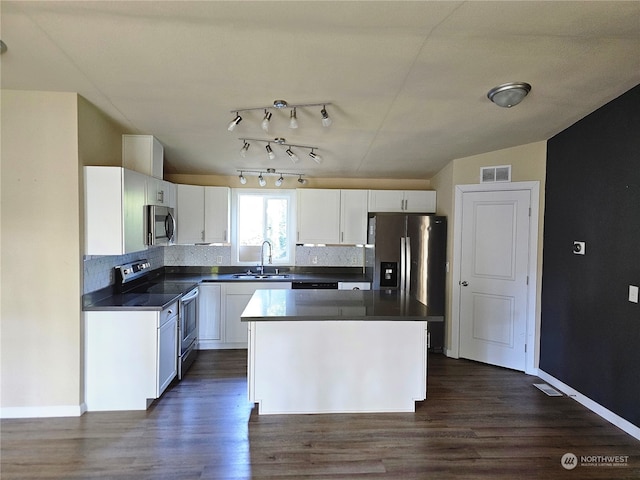 kitchen with sink, a center island, white cabinetry, appliances with stainless steel finishes, and dark hardwood / wood-style flooring