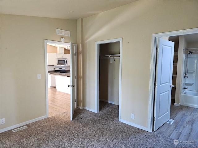 unfurnished bedroom with light carpet and vaulted ceiling