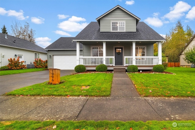 view of front of property featuring cooling unit, a garage, a front lawn, and a porch